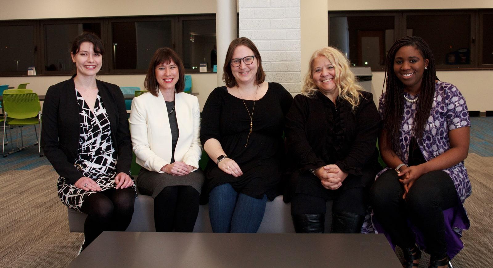 图为五名微笑的妇女坐在查塔姆冰球突破mg登录网址