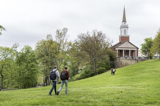 当学生们步行去上课时，巨大的绿叶树排列在冰球突破app的学术院落旁. 