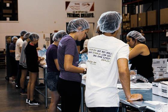 图为冰球突破app的学生在食品银行做志愿者